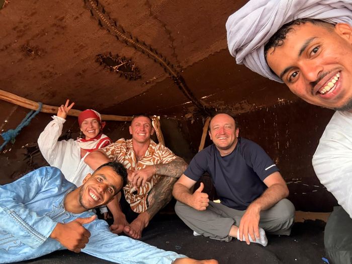 Notre équipe et un groupe de voyageurs réunis sous une tente berbère